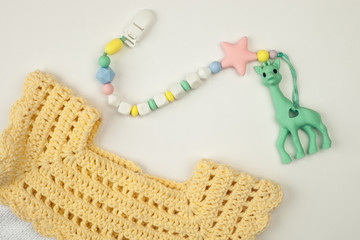Baby girl accessories concept: cotton dress and teether toy