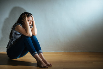 Fototapeta na wymiar fear sadness victim girl sitting on wooden floor