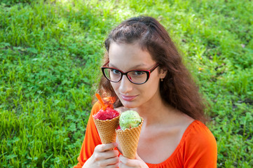 Girl with glasses and an orange dress is holding ice cream