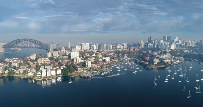 Wide panoramic rotation above Sydney Harbour from Fort Denison to wealthy North Shore suburbs of Sydney in soft morning sun light.