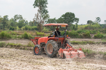 Obraz premium Thai farmers are using a tractor to prepare the soil for growing rice.