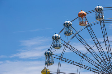 Ferris wheel in blue sky high up in the air