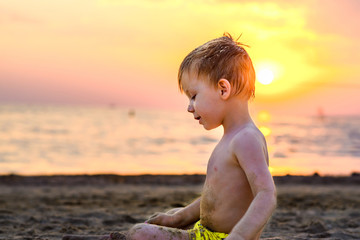 the child plays with the sand on the beach