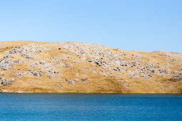Blue lake near yellow rocks in nature