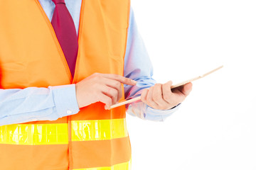 Young confident asian man, orange safety hat, orange safety jacket, safety glass, red tie, blue shirt on white using smart device.