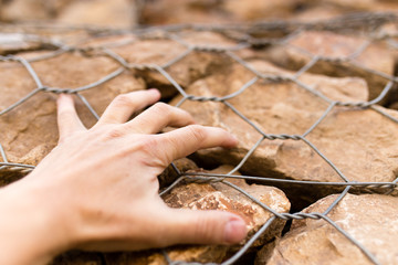 Man's hand on a stone wall
