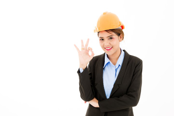 Young confident asian woman, orange safety hat, black suit, blue shirt on white posing okay sign.