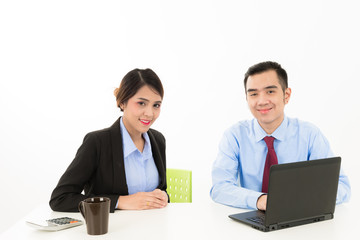 Obraz premium Young attractive confident Asian male business man and woman sitting on desk discussing work over coffee with laptop document on white background