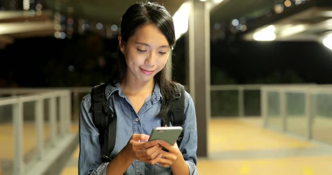 Woman use of mobile phone in the city at night