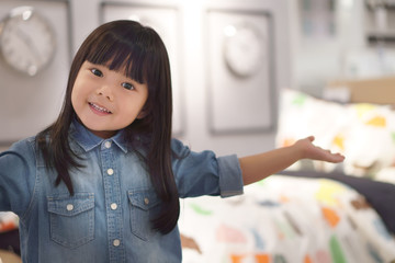 Asian children cute or kid girl wearing jeans and present or show my bedroom with modern clock on warm white because crazy or sales with space on soft focus and little noise at full picture size