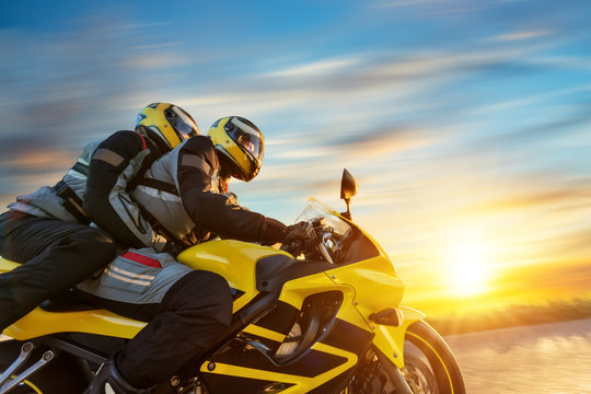 Fototapeta Motorbikers on sports motorbike riding in sunset
