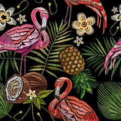 Fototapeta premium Embroidery flamingo , palm tree leaves, pineapple, coconut tropical seamless pattern. Fashionable embroidery pink flamingos, tropical summer background. Fashionable template for design of clothes