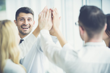 The happy people greeting with a high five