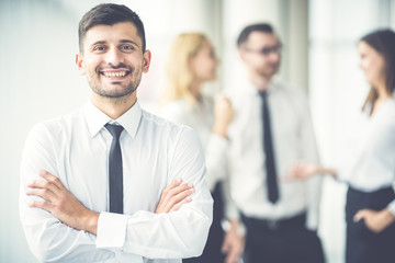 The happy businessman near the colleagues