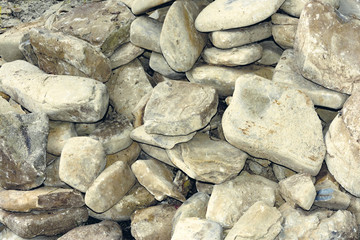 Background texture heap of large pebble stones and sandstone close-up as background under the inscription