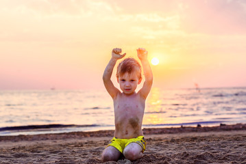 the child plays with the sand on the beach