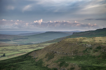 Stunning dawn sunrise landscape image from Higger Tor towards Hope Valley layered in fog in Summer in Peak District England