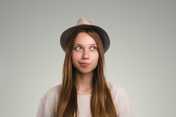 Positive casual woman posing. Emotional girl portrait. Young female with hat. The model is looking away.