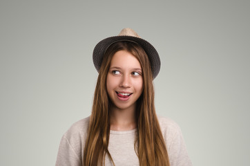 Positive casual woman posing. Emotional girl portrait. Young female with hat. The model is looking away.