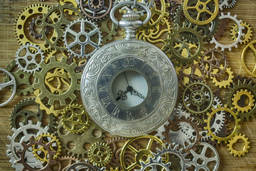 Old vintage pocket watch among the different gears - watch details, steampunk style close-up hdr image