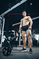 Obraz na płótnie Canvas Handsome model young man training legs in gym