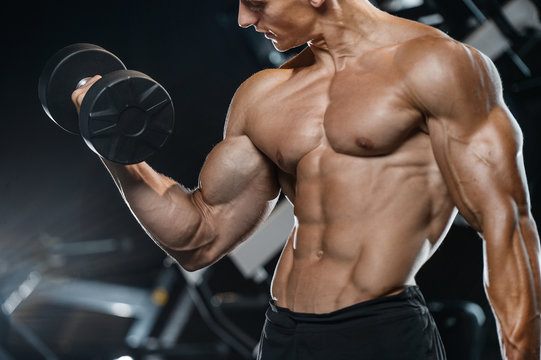 Handsome model young man training arms in gym