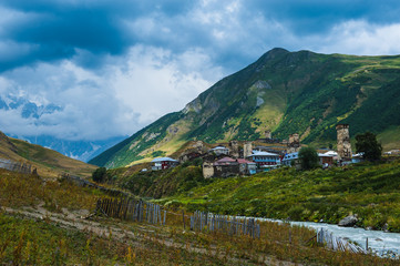 Village Ushguli landscape with massive rocky mountains Bezengi wall, Shkhara on the background in Svaneti, Georgia