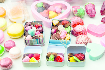 photo handmade soap in the form of sweets, heart, canteen, fruit, in boxes on the table close-up as background under the inscription