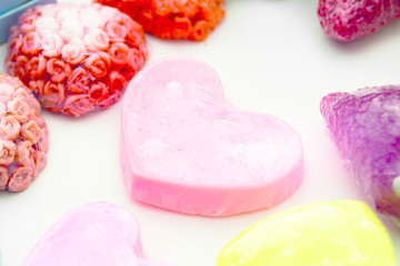 photo handmade soap in the form of sweets, heart, canteen, fruit, in boxes on the table close-up as background under the inscription