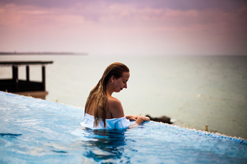 Woman in a swimming pool with Black sea view, sunrise