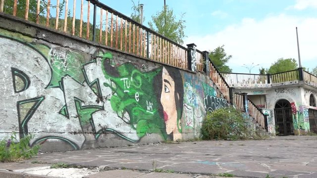 Ghost town with murals and minaret in Consonno, Italy. Abandoned construction with graffiti and wild vegetation, desolate and scary place, ghost town
