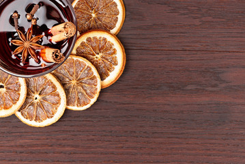 Fototapeta na wymiar mulled wine and orange slices on wooden background