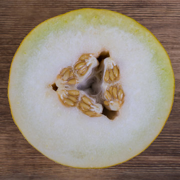Half of melon on the wooden background, top view