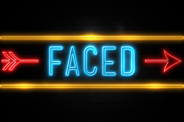Faced  - fluorescent Neon Sign on brickwall Front view