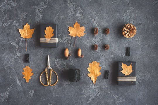 Autumn composition. Gifts, autumn golden leaves, pine cones, accessories on black background. Flat lay, top view