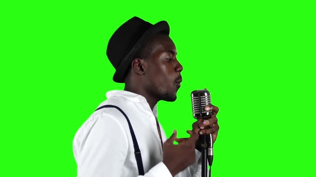 Male african american musician half of the turnover singing in a recording studio. Green screen. Slow motion. Close up