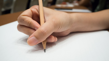 Women hand with pencil writing on paper