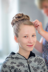 ein junges, blondes Mädchen zur Vorbereitung von Jugendweihe / Konfirmation beim Friseur /...