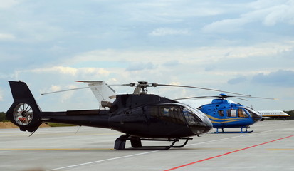 black and blue helicopter at the airport, background of cloudy sky