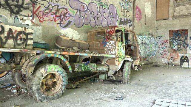 Abandoned lorry in ghost building with murals in Consonno, Italy. Destroyed truck and architecture with graffiti in dead town, demolished vehicle in desolated place