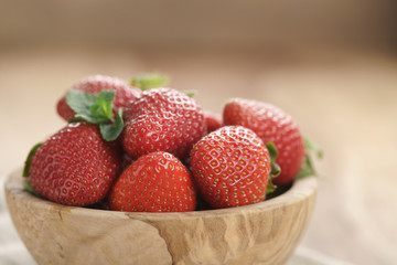 fresh strawberries in bowl on wood table
