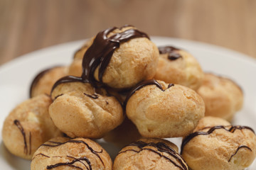 closeup profiteroles with fine dark chocolate on plate