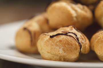 closeup profiteroles with fine dark chocolate on plate