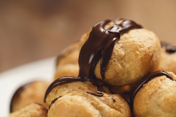 closeup profiteroles with fine dark chocolate on plate