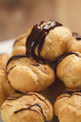 closeup profiteroles with fine dark chocolate on plate