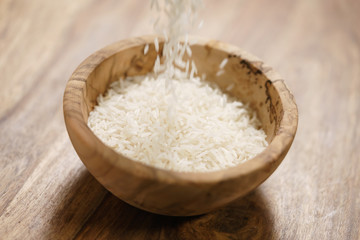 dry basmati rice fall in wood bowl on table