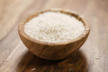 dry basmati rice in wood bowl on table