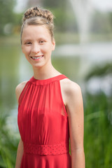 junges, hübsches Mädchen im Sommer mit Hochsteckfrisur und rotem Sommerkleid beim Fotoshooting...