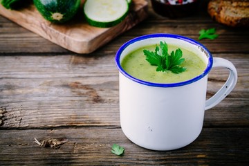 homemade green zucchini cream soup with parsley in mugs