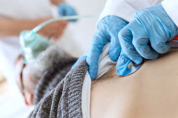 Patient in der Intensivstation, Beatmung und Untersuchung mit dem Stethoskop